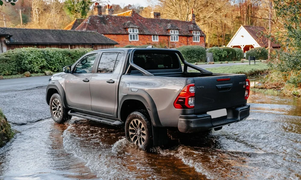 Фото Toyota Hilux (2024) — вид сзади, фото 3. Графика фонарей, бампер и оформление пятой двери. Насадки выхлопа или их имитация внизу бампера различают версии Toyota Hilux (2024) — вид сзади, фото 3