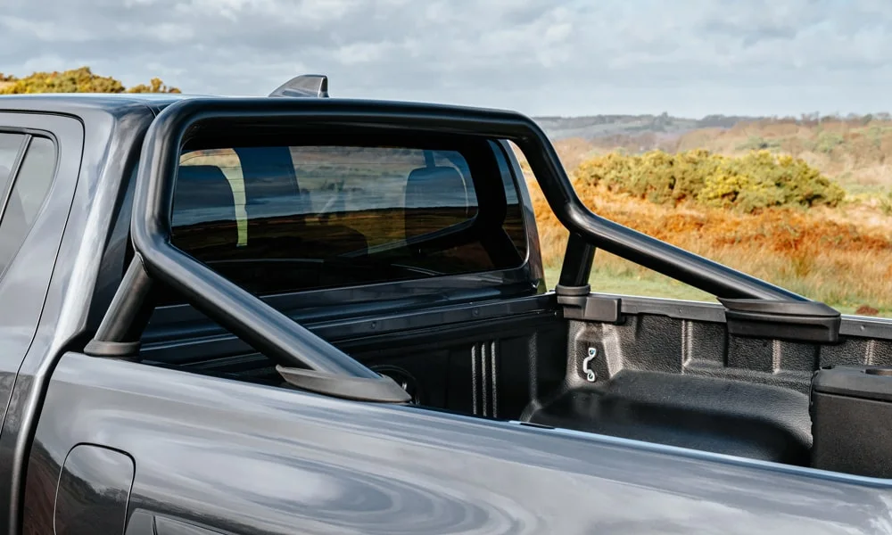 Фото Toyota Hilux (2024) — вид сзади, фото 4. Чёрный кузов сзади — фонари и бампер определяют ночной образ модели Toyota Hilux (2024) — вид сзади, фото 4