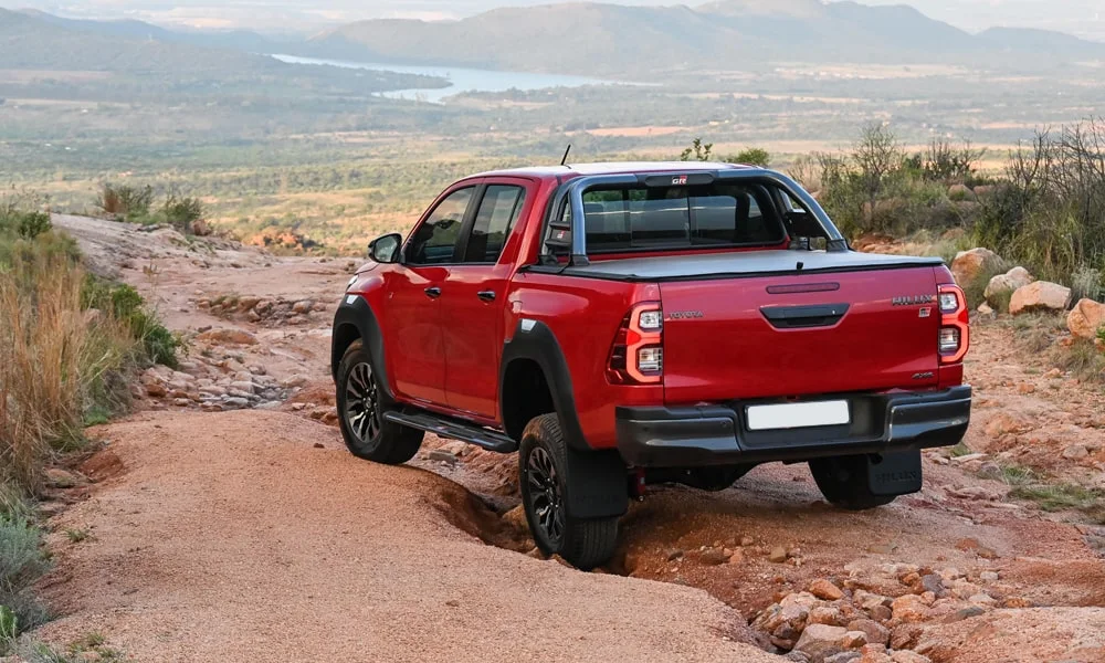 Фото Toyota Hilux (2024) — вид сзади, фото 7. Красный кузов сзади — фонари и бампер определяют ночной образ модели. Насадки выхлопа или их имитация внизу бампера различают версии Toyota Hilux (2024) — вид сзади, фото 7