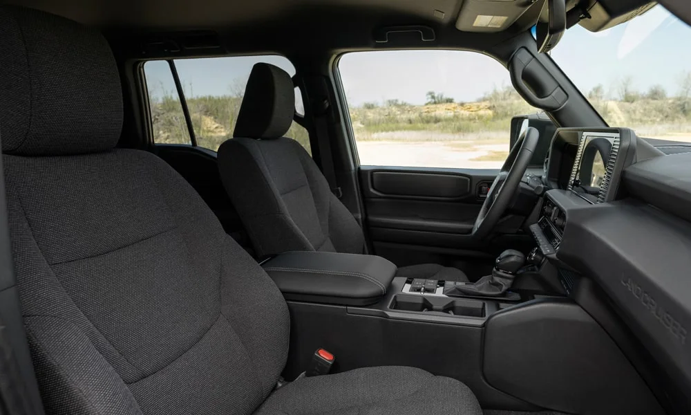 Фото Toyota Land Cruiser Prado (2024) — передние сиденья. Профиль кресел: боковая поддержка и подголовники. Выраженная боковая поддержка держит в поворотах Toyota Land Cruiser Prado (2024) — передние сиденья