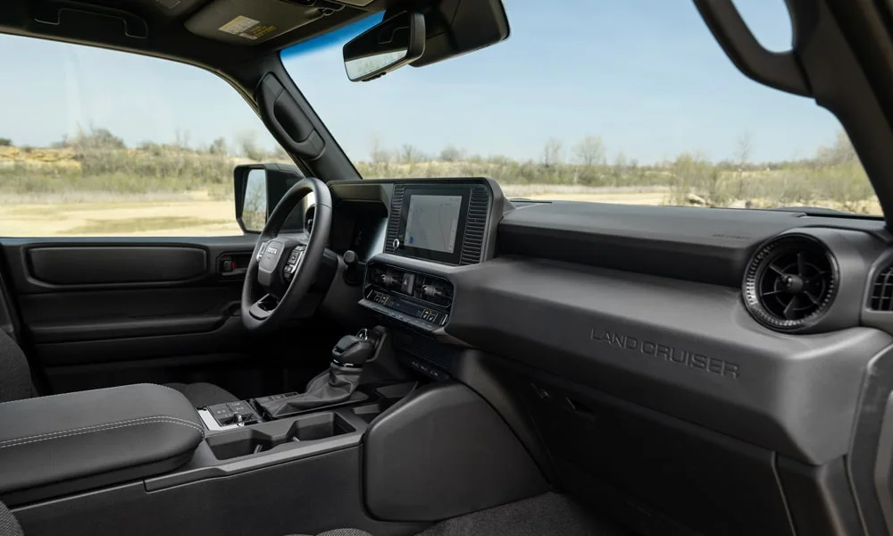 Фото Toyota Land Cruiser Prado (2024) — интерьер. Общий план салона: архитектура панели, консоль и кресла Toyota Land Cruiser Prado (2024) — интерьер