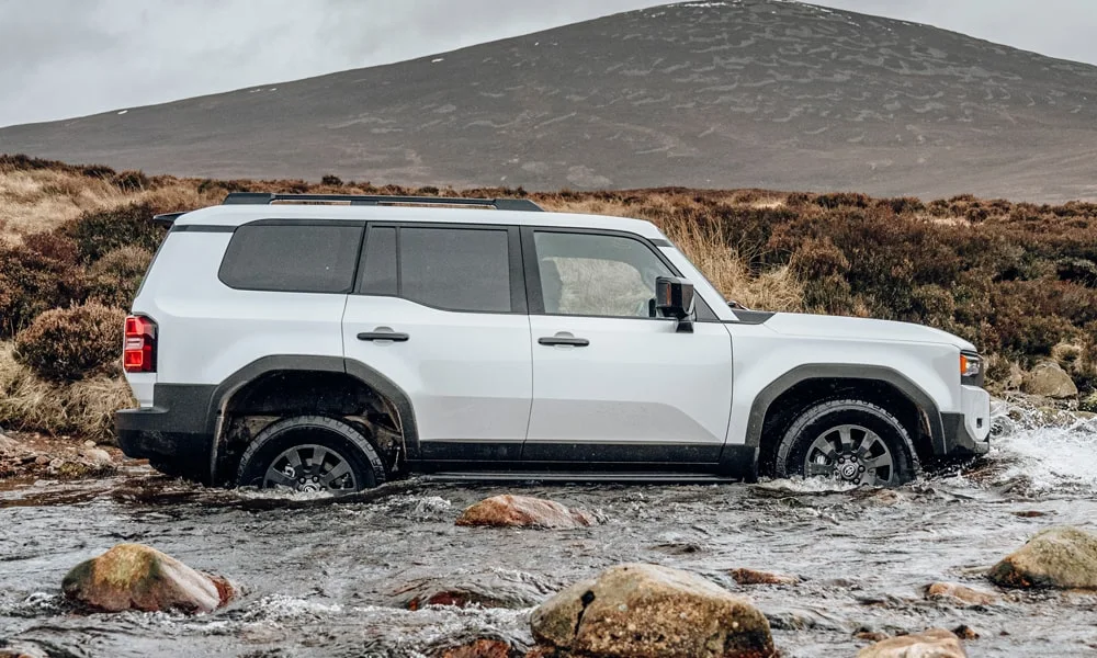Фото Toyota Land Cruiser Prado (2024) — вид сзади, фото 4. Белый кузов сзади — фонари и бампер определяют ночной образ модели Toyota Land Cruiser Prado (2024) — вид сзади, фото 4
