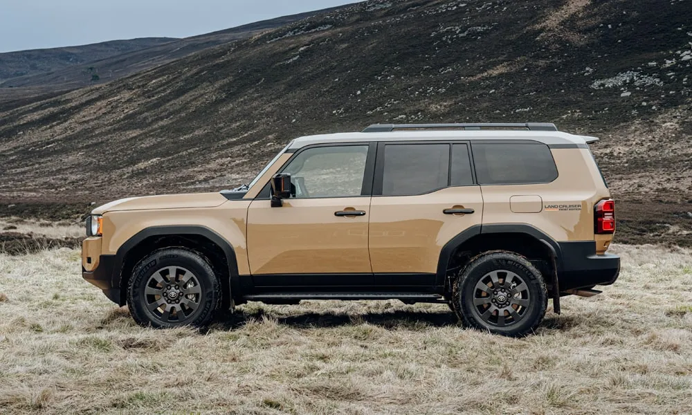 Фото Toyota Land Cruiser Prado (2024) — вид сбоку, фото 4. Профиль кузова: колёсная база, свесы и линия остекления. Хромированные или чёрные молдинги окон отличают комплектации Toyota Land Cruiser Prado (2024) — вид сбоку, фото 4