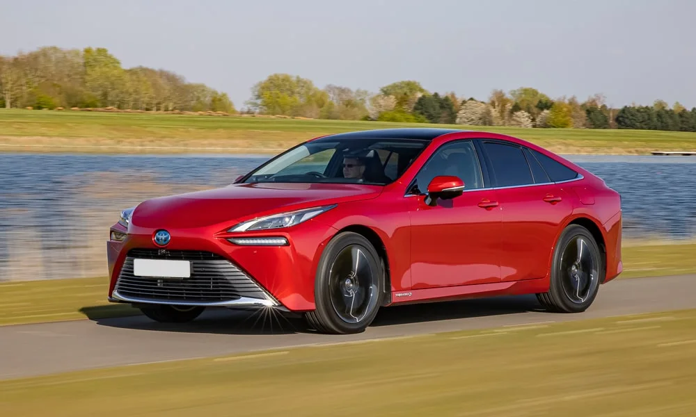 Фото Toyota Mirai (2024) — вид спереди, фото 8. Красный кузов, строгая симметрия оптики — базовый ракурс знакомства с дизайном Toyota Mirai (2024) — вид спереди, фото 8
