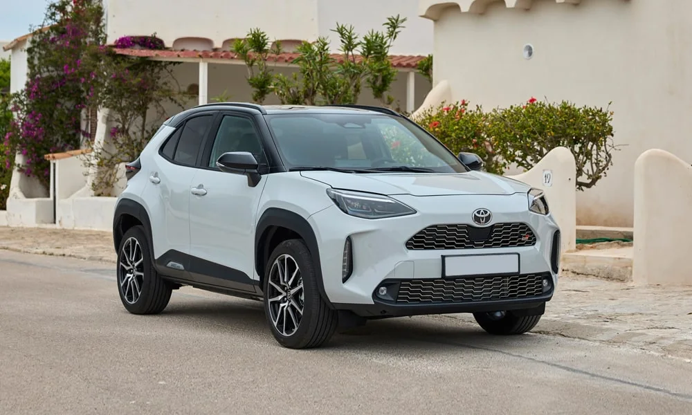 Фото Toyota Yaris Cross — вид спереди, фото 8. Белый кузов, строгая симметрия оптики — базовый ракурс знакомства с дизайном. Дневные ходовые огни включаются автоматически с запуском Toyota Yaris Cross — вид спереди, фото 8