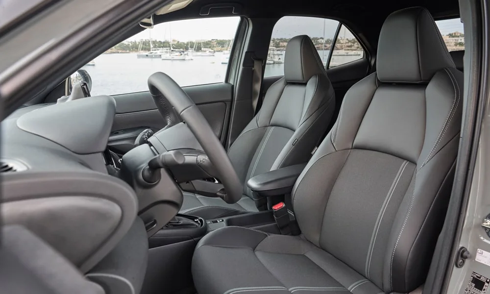 Фото Toyota Yaris Cross — передние сиденья. Профиль кресел: боковая поддержка и подголовники. Выраженная боковая поддержка держит в поворотах Toyota Yaris Cross — передние сиденья