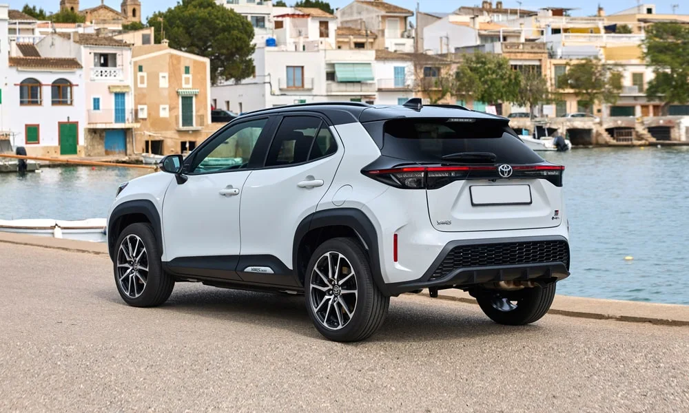 Фото Toyota Yaris Cross — вид сзади, фото 6. Корма в белом цвете: графика фонарей и пластика пятой двери. Насадки выхлопа или их имитация внизу бампера различают версии Toyota Yaris Cross — вид сзади, фото 6