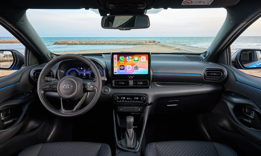 Фото Toyota Yaris — передняя панель. Компоновка экранов, дефлекторов и консоли. Мягкие материалы верхнего яруса и вставки задают уровень интерьера Toyota Yaris — передняя панель