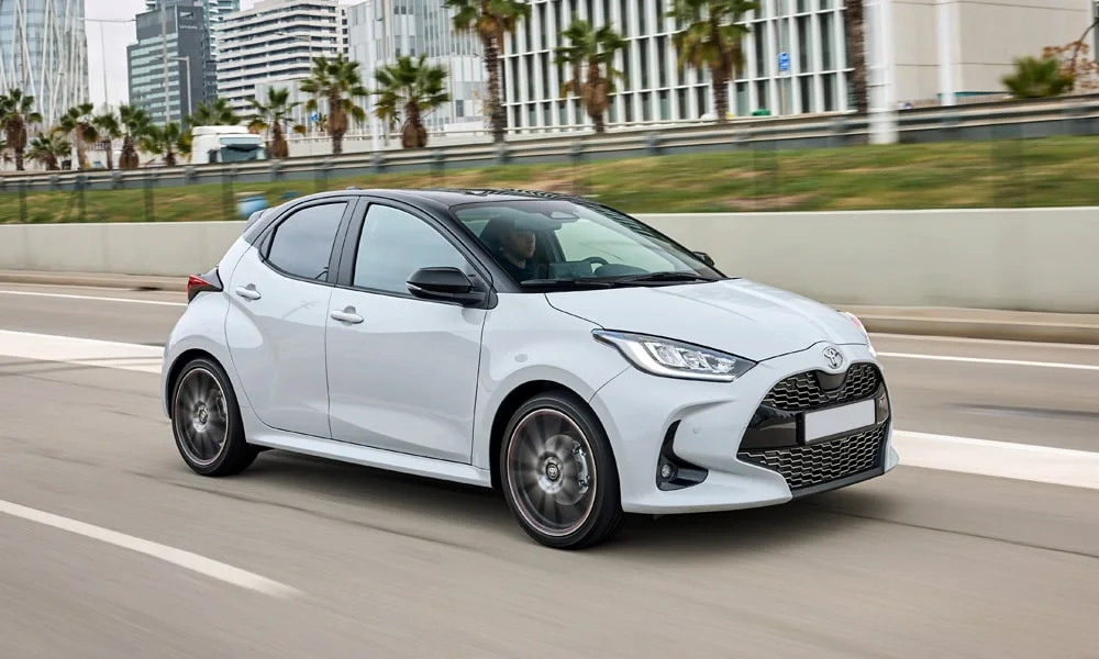 Фото Toyota Yaris — вид спереди, фото 3. Передок в белом исполнении — крупная светотехника и выразительный бампер. Рисунок ходовых огней — подпись модели, по нему её узнают в потоке Toyota Yaris — вид спереди, фото 3