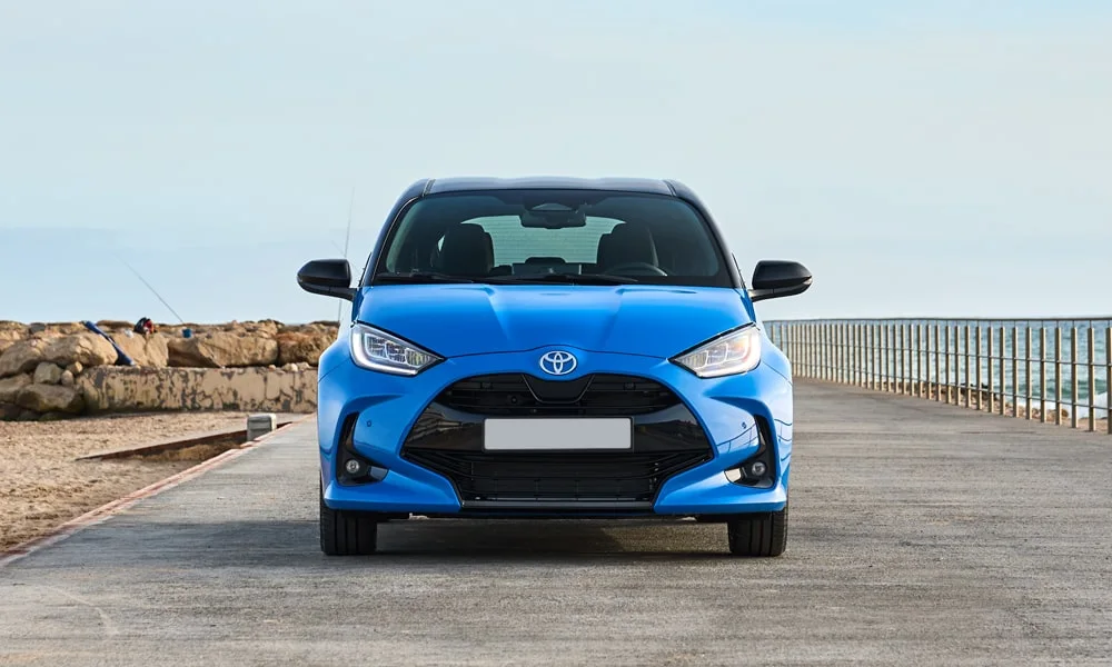 Фото Toyota Yaris — вид спереди, фото 8. Синий кузов, строгая симметрия оптики — базовый ракурс знакомства с дизайном. Дневные ходовые огни включаются автоматически с запуском Toyota Yaris — вид спереди, фото 8