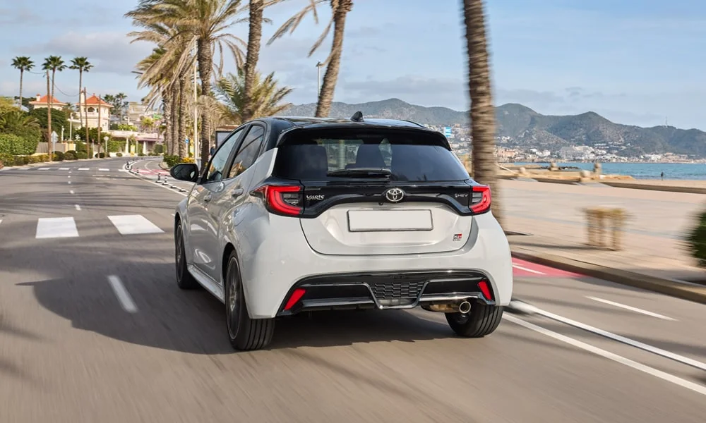 Фото Toyota Yaris — вид сзади, фото 3. Корма в белом цвете: графика фонарей и пластика пятой двери Toyota Yaris — вид сзади, фото 3