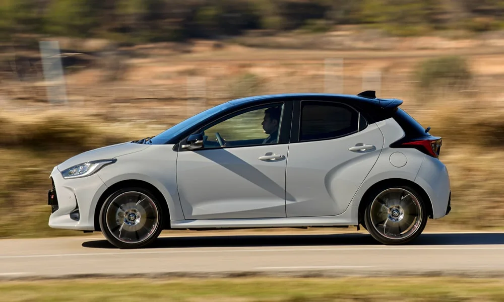 Фото Toyota Yaris — вид сбоку, фото 3. Белый кузов в профиль — пропорции, высота посадки и дизайн дисков. Длинная база — простор второго ряда; короткие свесы упрощают парковку Toyota Yaris — вид сбоку, фото 3