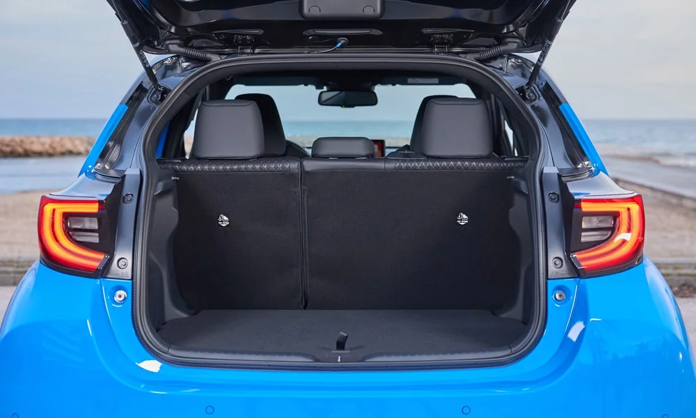 Фото Toyota Yaris — багажник. Грузовой отсек с открытой дверью: погрузочная высота и ширина проёма. Под полом обычно размещены органайзер, докатка или ремкомплект Toyota Yaris — багажник