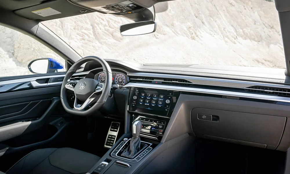 Фото Volkswagen Arteon (2024) — передняя панель. Передняя панель в тёмно-синей отделке: расположение экранов и дефлекторов. Мягкие материалы верхнего яруса и вставки задают уровень интерьера Volkswagen Arteon (2024) — передняя панель