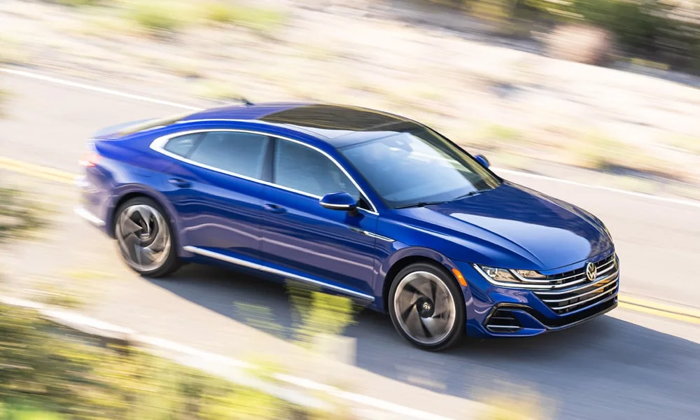 Фото Volkswagen Arteon (2024) — вид спереди, фото 8. Передок в синем исполнении — крупная светотехника и выразительный бампер. Дневные ходовые огни включаются автоматически с запуском Volkswagen Arteon (2024) — вид спереди, фото 8