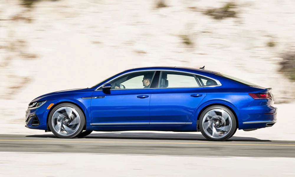 Фото Volkswagen Arteon (2024) — вид сбоку, фото 2. Синий кузов в профиль — пропорции, высота посадки и дизайн дисков Volkswagen Arteon (2024) — вид сбоку, фото 2