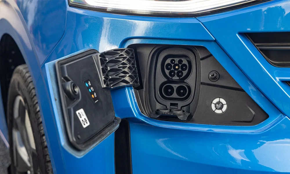 Фото Volkswagen Caravelle (2024) — лючок топливного бака. Разъём и индикация процесса зарядки. Индикатор рядом с разъёмом показывает статус зарядки цветом Volkswagen Caravelle (2024) — лючок топливного бака