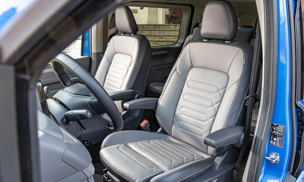 Фото Volkswagen Caravelle (2024) — передние сиденья. Профиль кресел: боковая поддержка и подголовники. Выраженная боковая поддержка держит в поворотах Volkswagen Caravelle (2024) — передние сиденья