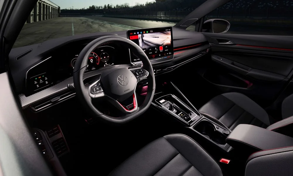 Фото Volkswagen Golf GTI (2024) — интерьер. Общий план салона: архитектура панели, консоль и кресла Volkswagen Golf GTI (2024) — интерьер