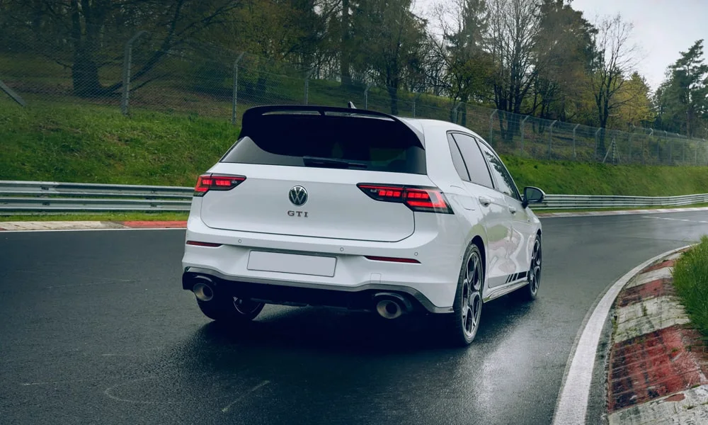 Фото Volkswagen Golf GTI (2024) — вид сзади, фото 5. Линия крыши, стойки и задняя дверь в белом исполнении. Насадки выхлопа или их имитация внизу бампера различают версии Volkswagen Golf GTI (2024) — вид сзади, фото 5