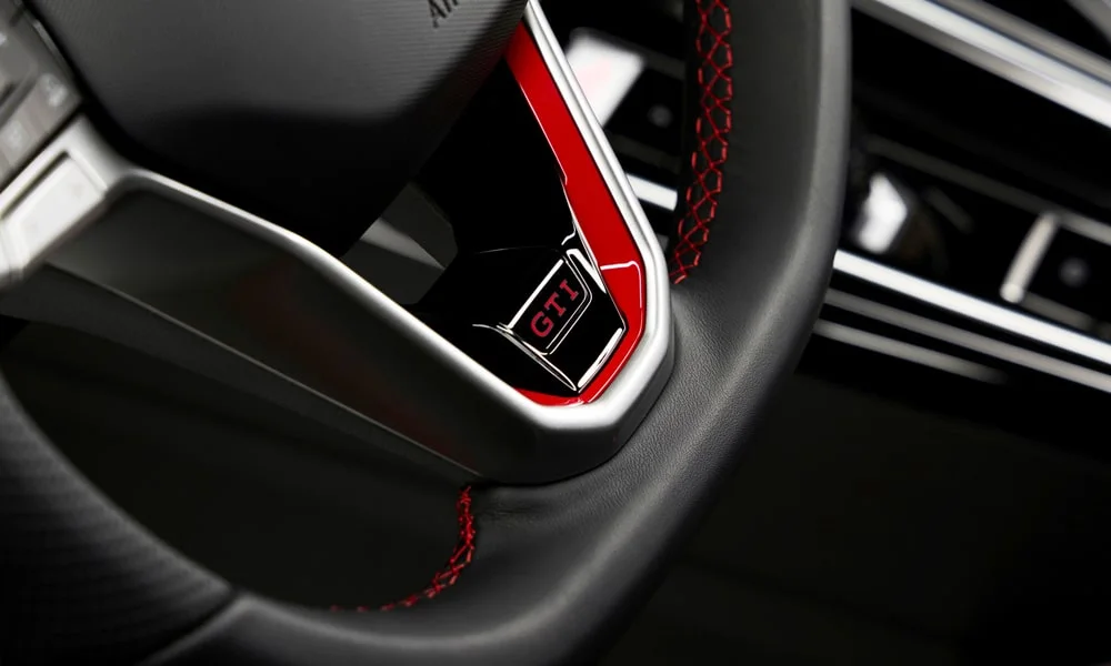 Фото Volkswagen Golf GTI (2024) — руль, фото 2. Обшивка обода и компоновка спиц крупным планом. Правильная посадка: руки на «9 и 3», приборы читаются поверх обода Volkswagen Golf GTI (2024) — руль, фото 2
