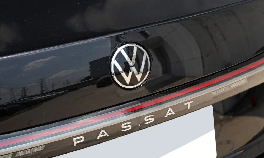 Фото Volkswagen Passat (2024) — эмблема. Фирменный шильдик на кузове — знак принадлежности к марке. Шильдик версии на корме помогает отличать комплектации Volkswagen Passat (2024) — эмблема