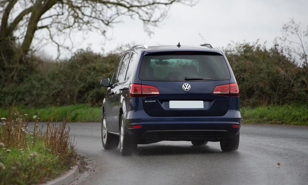 Фото Volkswagen Sharan — вид сзади, фото 7. Корма в синем цвете: графика фонарей и пластика пятой двери. Светодиодная полоса или раздельные секции — задняя оптика стала главным украшением кормы Volkswagen Sharan — вид сзади, фото 7