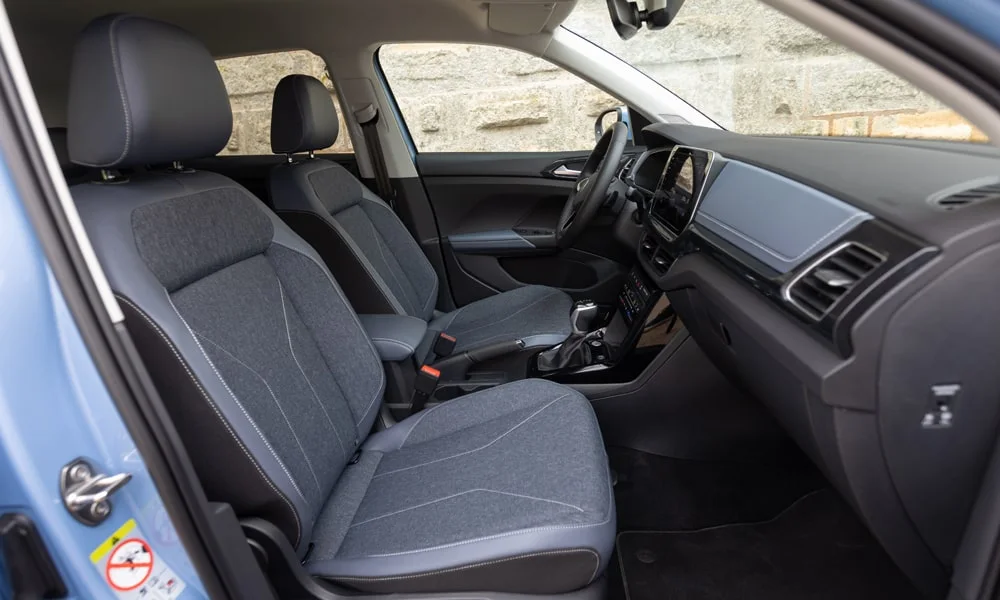 Фото Volkswagen T-Cross — интерьер. Общий план салона: архитектура панели, консоль и кресла. Уровень отделки читается по стыкам панелей и мягким поверхностям в зонах касания Volkswagen T-Cross — интерьер