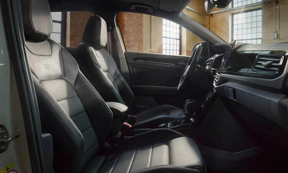 Фото Volkswagen T-Roc — интерьер, фото 2. Салон в светло-серой отделке: архитектура передней панели, консоль и кресла. Уровень отделки читается по стыкам панелей и мягким поверхностям в зонах касания Volkswagen T-Roc — интерьер, фото 2