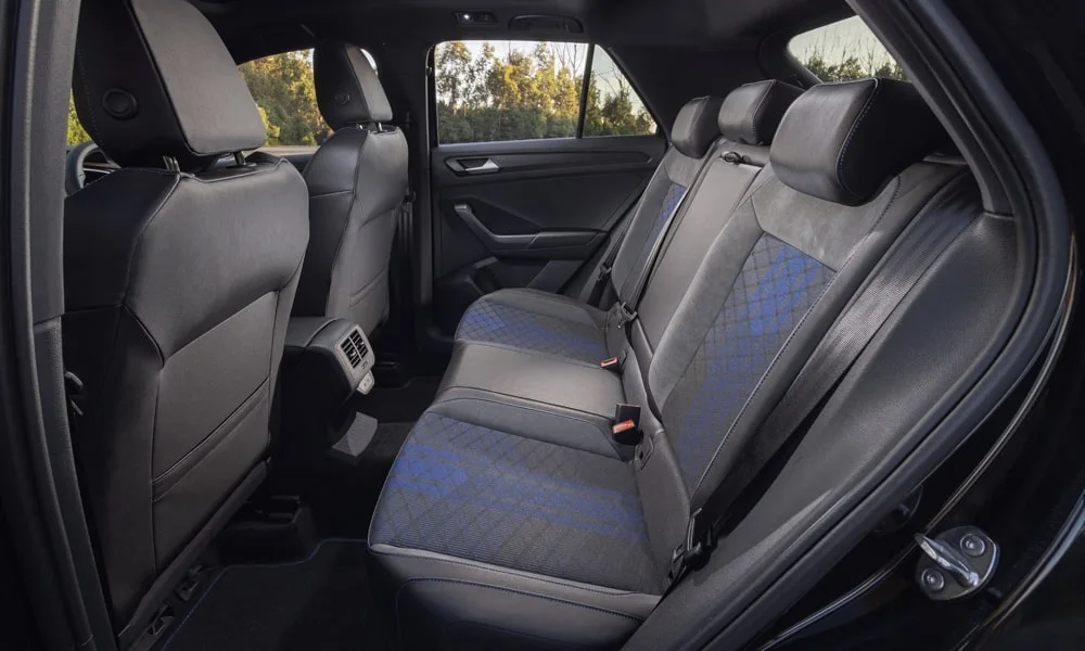 Фото Volkswagen T-Roc — задние сиденья. Второй ряд: профиль дивана, подголовники и обивка из перфорированной коже. Спинки складываются под длинные грузы у большинства версий Volkswagen T-Roc — задние сиденья
