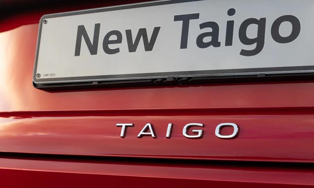 Фото Volkswagen Taigo — эмблема. Фирменный шильдик на кузове — знак принадлежности к марке. Шильдик версии на корме помогает отличать комплектации Volkswagen Taigo — эмблема