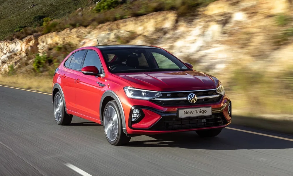 Фото Volkswagen Taigo — вид спереди, фото 4. Кузов в красном цвете: рисунок оптики и решётки задаёт узнаваемое «лицо» модели. Рисунок ходовых огней — подпись модели, по нему её узнают в потоке Volkswagen Taigo — вид спереди, фото 4