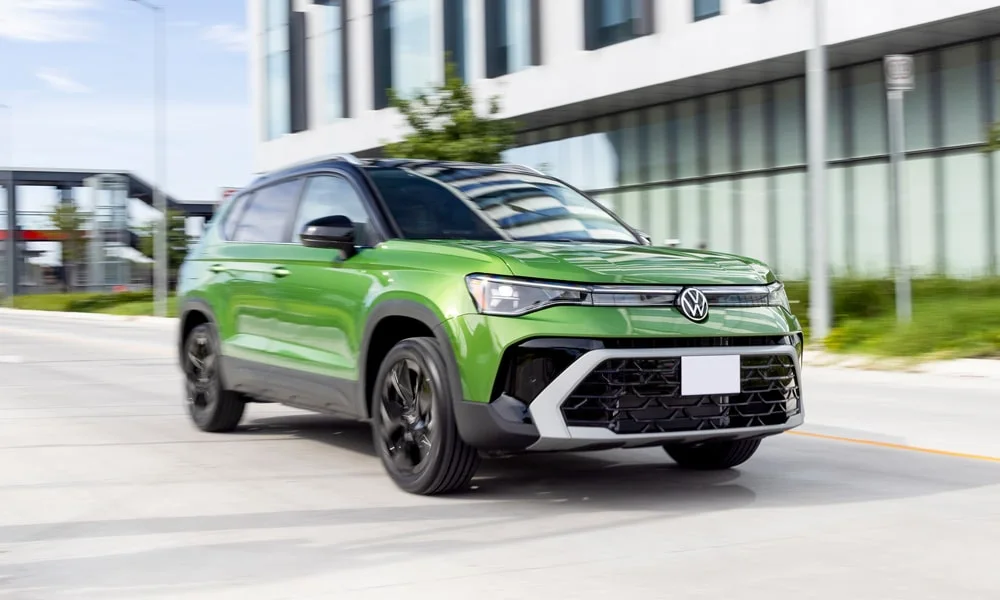Фото Volkswagen Taos (2024) — вид спереди, фото 4. Зелёный кузов, строгая симметрия оптики — базовый ракурс знакомства с дизайном. Рисунок ходовых огней — подпись модели, по нему её узнают в потоке Volkswagen Taos (2024) — вид спереди, фото 4