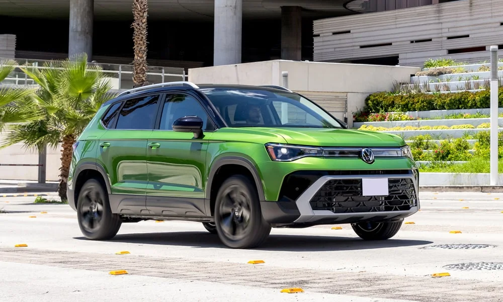 Фото Volkswagen Taos (2024) — вид спереди, фото 6. Кузов в зелёном цвете: рисунок оптики и решётки задаёт узнаваемое «лицо» модели. Дневные ходовые огни включаются автоматически с запуском Volkswagen Taos (2024) — вид спереди, фото 6