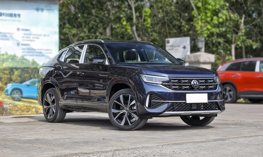 Фото Volkswagen Tayron X — вид спереди, фото 6. Кузов в синем цвете: рисунок оптики и решётки задаёт узнаваемое «лицо» модели. Рисунок ходовых огней — подпись модели, по нему её узнают в потоке Volkswagen Tayron X — вид спереди, фото 6