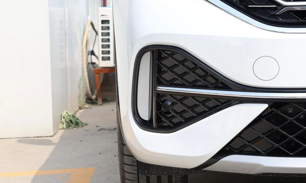 Фото Volkswagen Tayron X — решётка радиатора. Фирменный рисунок облицовки — визитная карточка марки. Активные жалюзи за решёткой закрываются на трассе ради аэродинамики — есть у ряда моделей Volkswagen Tayron X — решётка радиатора