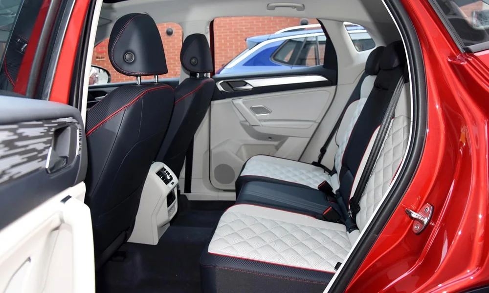 Фото Volkswagen Tayron X — задние сиденья. Задний диван в перфорированной коже: посадка и центральный подлокотник. Крепления ISOFIX для детских кресел — в основании спинки Volkswagen Tayron X — задние сиденья