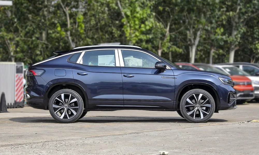 Фото Volkswagen Tayron X — вид сбоку, фото 3. Сбоку читаются линия остекления и характер выштамповок на синем кузове. Длинная база — простор второго ряда; короткие свесы упрощают парковку Volkswagen Tayron X — вид сбоку, фото 3