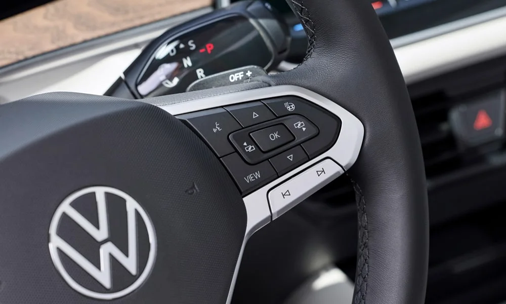 Фото Volkswagen Tayron (2024) — руль. Обшивка обода и компоновка спиц крупным планом. Клавиши на спицах управляют медиа, круизом и ассистентами — руки остаются на руле Volkswagen Tayron (2024) — руль