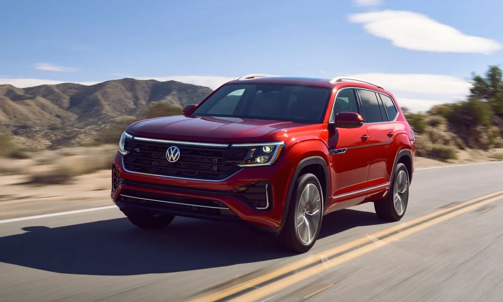Фото Volkswagen Teramont (2024) — вид спереди, фото 4. Кузов в красном цвете: рисунок оптики и решётки задаёт узнаваемое «лицо» модели. Рисунок ходовых огней — подпись модели, по нему её узнают в потоке Volkswagen Teramont (2024) — вид спереди, фото 4