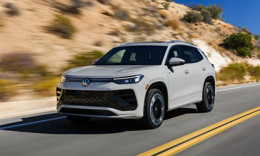 Фото Volkswagen Tiguan (2024) — вид спереди, фото 7. Кузов в белом цвете: рисунок оптики и решётки задаёт узнаваемое «лицо» модели. Дневные ходовые огни включаются автоматически с запуском Volkswagen Tiguan (2024) — вид спереди, фото 7