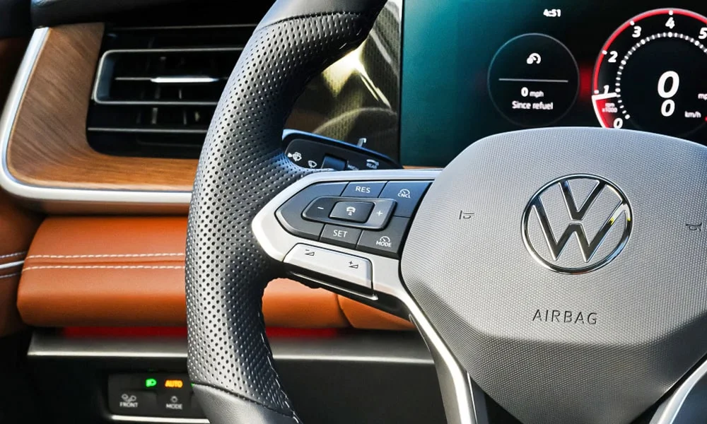Фото Volkswagen Tiguan (2024) — руль, фото 2. Обшивка обода и компоновка спиц крупным планом. Клавиши на спицах управляют медиа, круизом и ассистентами — руки остаются на руле Volkswagen Tiguan (2024) — руль, фото 2