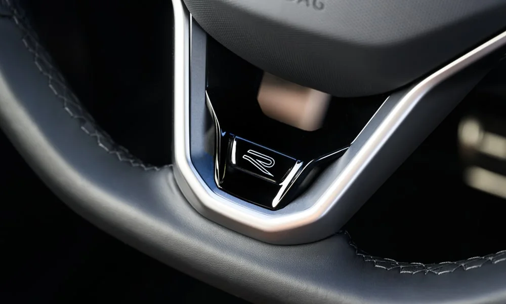 Фото Volkswagen Tiguan (2024) — руль, фото 4. Обшивка обода и компоновка спиц крупным планом. Правильная посадка: руки на «9 и 3», приборы читаются поверх обода Volkswagen Tiguan (2024) — руль, фото 4