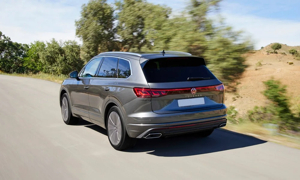 Фото Volkswagen Touareg (2024) — вид сзади, фото 4. Корма в сером цвете: графика фонарей и пластика пятой двери. Светодиодная полоса или раздельные секции — задняя оптика стала главным украшением кормы Volkswagen Touareg (2024) — вид сзади, фото 4