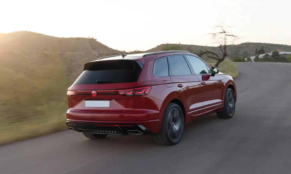 Фото Volkswagen Touareg (2024) — вид сзади, фото 10. Красный кузов сзади — фонари и бампер определяют ночной образ модели. Светодиодная полоса или раздельные секции — задняя оптика стала главным украшением кормы Volkswagen Touareg (2024) — вид сзади, фото 10