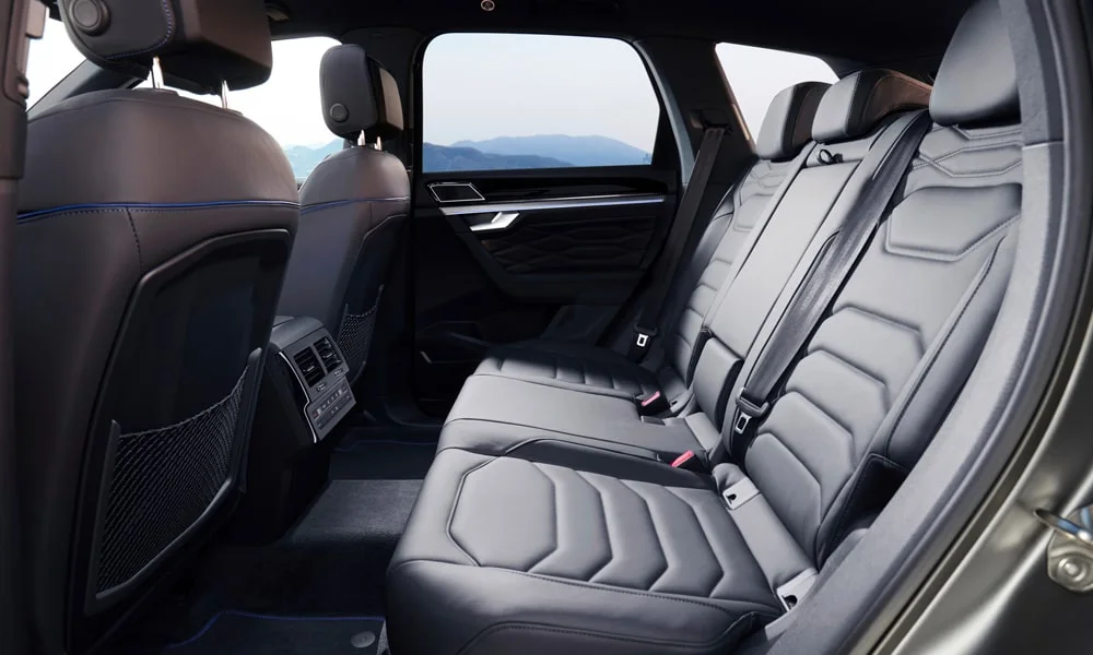 Фото Volkswagen Touareg (2024) — задние сиденья, фото 3. Посадка второго ряда: подголовники и подлокотник. Плоский пол упрощает посадку втроём Volkswagen Touareg (2024) — задние сиденья, фото 3