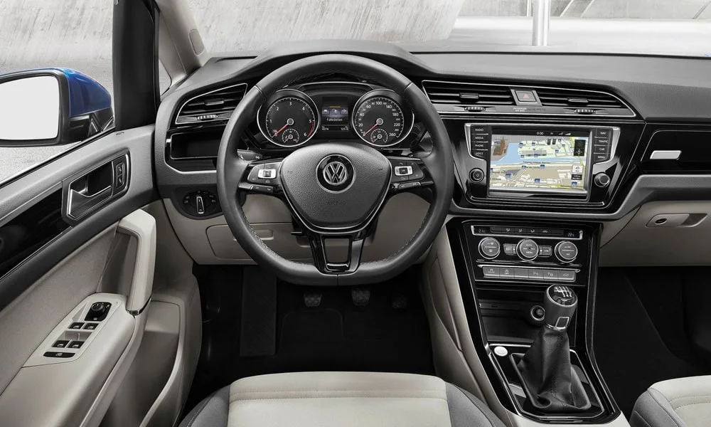 Фото Volkswagen Touran — передняя панель. Компоновка экранов, дефлекторов и консоли. Мягкие материалы верхнего яруса и вставки задают уровень интерьера Volkswagen Touran — передняя панель