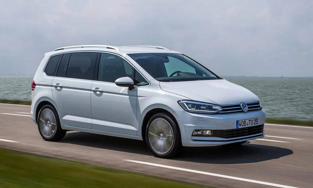 Фото Volkswagen Touran — вид спереди, фото 9. Серебристый кузов, строгая симметрия оптики — базовый ракурс знакомства с дизайном. Рисунок ходовых огней — подпись модели, по нему её узнают в потоке Volkswagen Touran — вид спереди, фото 9