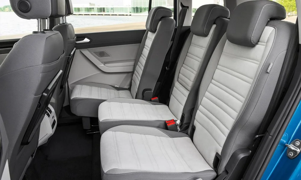 Фото Volkswagen Touran — задние сиденья. Посадка второго ряда: подголовники и подлокотник. Плоский пол упрощает посадку втроём Volkswagen Touran — задние сиденья