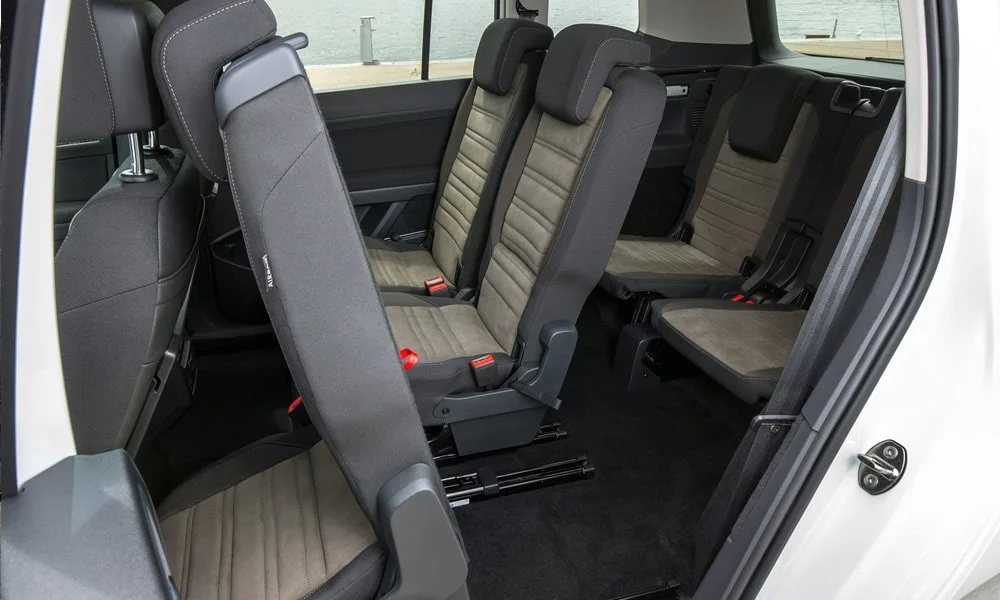 Фото Volkswagen Touran — задние сиденья, фото 2. Задний диван в практичной ткани: посадка и центральный подлокотник. Плоский пол упрощает посадку втроём Volkswagen Touran — задние сиденья, фото 2